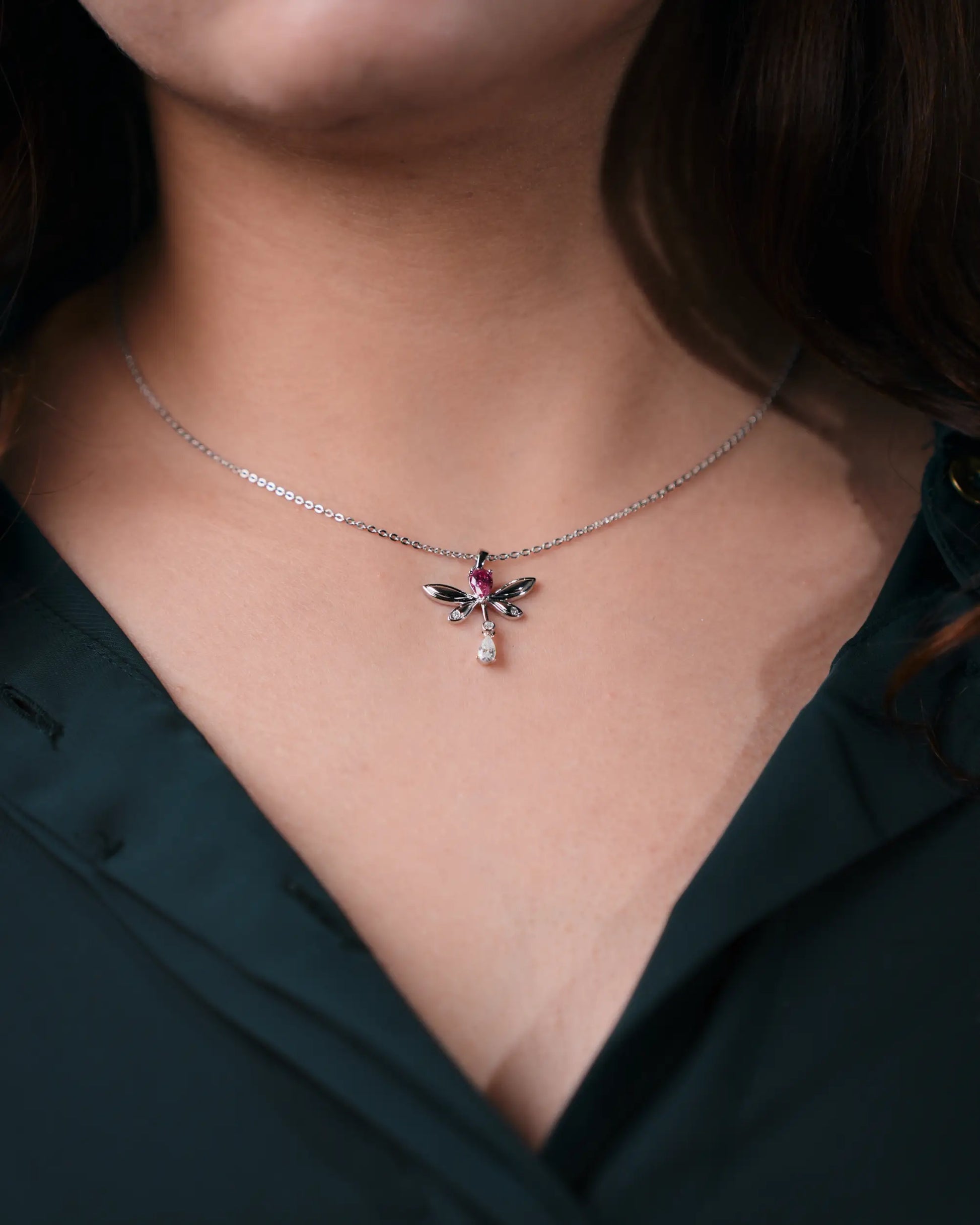 Necklace with a detailed pendant worn by a person against a dark background